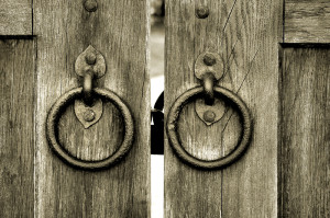 ancient wooden gate with door knocker rings